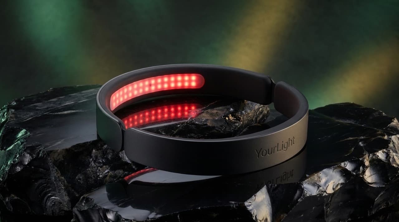 The YourLight Band, its red LED array lit, resting on dark obsidian